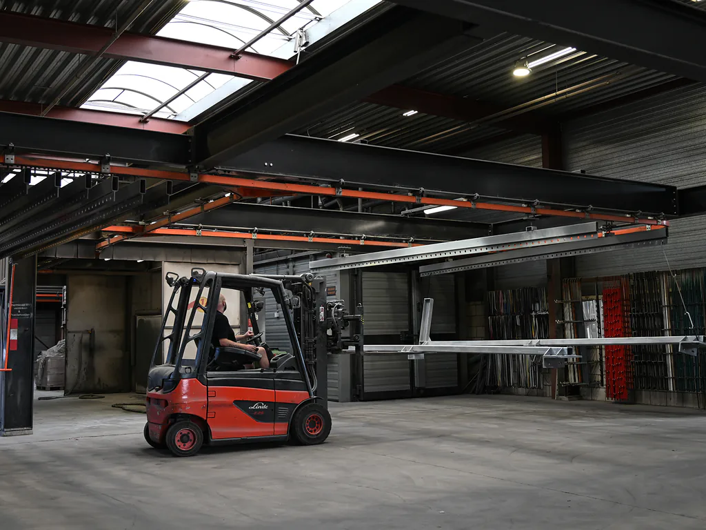 Heftruck rijdt met een verzinkte ligger door de hal van Thermicoat